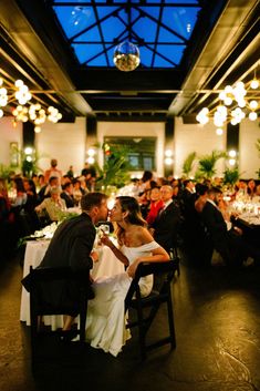 a bride and groom sharing a kiss at their wedding reception