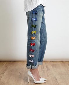 a woman wearing high heels and jeans with bows on the side