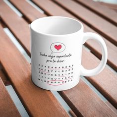 a white coffee mug sitting on top of a wooden bench with words written in spanish