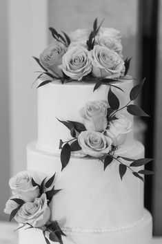 two tiered white wedding cake with flowers on top