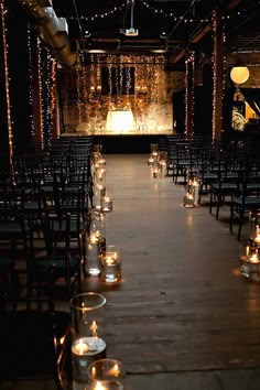 rows of chairs with lit candles on them