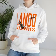 a woman wearing a white hoodie with an orange and black design on the front