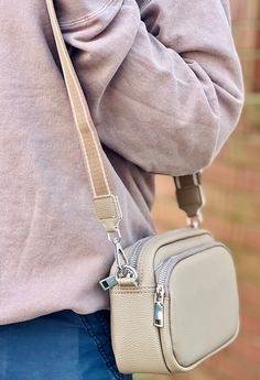 This Taupe Double Pocket Crossbody features dual zipper pockets and multiple compartments for added organization. Includes a crossbody strap for convenience and versatility. Versatile Crossbody Camera Bag With Zipper Pocket, Crossbody Strap, Zipper Pocket, Zipper