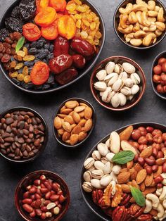 several bowls filled with nuts and dried fruits