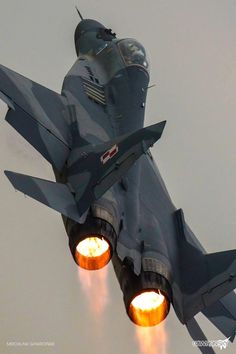 a fighter jet flying through the air with its lights on