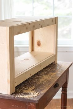 a close up of a piece of wood on top of a table with a window in the background