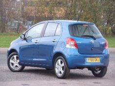 a blue car is parked on the side of the road