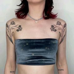 a woman with tattoos on her chest wearing a strapless top