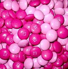 pink and white candies with the word m & m written on them in cursive writing