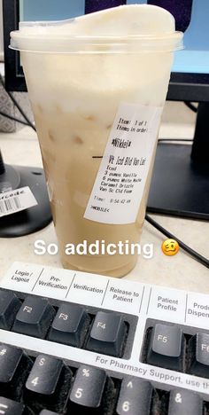 a plastic cup sitting on top of a computer keyboard