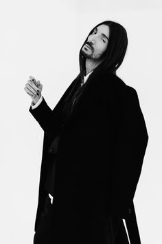 Man with long hair wearing a black suit and coat. Hair Wear, Black Suit, Black Suits