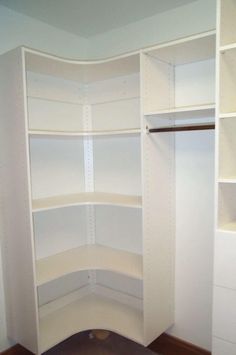 an empty closet with white shelves in it