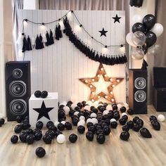 black and white party decorations with stars, balloons and streamers on the floor in front of a wall