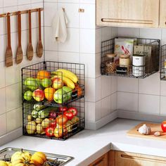 two metal baskets filled with fruit on top of a kitchen counter