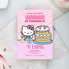 a hello kitty birthday party with a cake and flowers on the table next to it