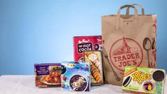 a paper bag filled with different types of food and some kind of snacks on top of a table