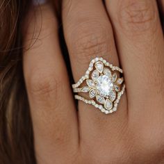 a woman's hand with a diamond ring on top of her finger and an engagement band