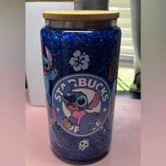 a blue glittered starbucks cup sitting on top of a counter