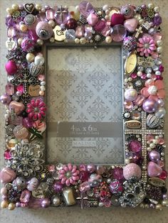 a pink and white photo frame with lots of beads