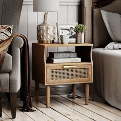 a living room with a chair, lamp and books on the end table in front of it