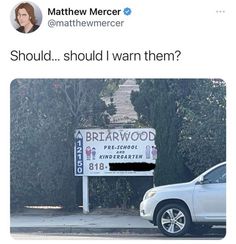 a white car parked in front of a sign