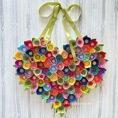 a heart shaped origami wreath made out of rolled up paper and colored markers