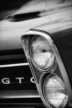 the front end of an old car with its lights turned on and headlamps showing