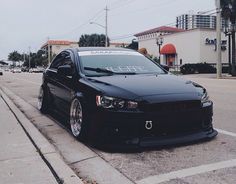 a black car is parked on the side of the road