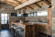 an open kitchen with stone walls and flooring is shown in this rustic style home