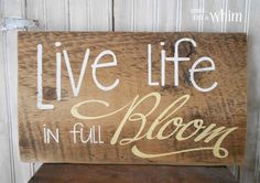 a wooden sign that says live life in full bloom