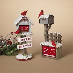 two mailboxes with red birds on them and one has a christmas tree in the background