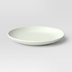 an empty white plate sitting on top of a table