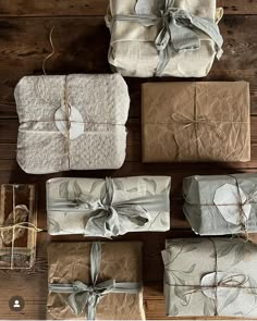 several wrapped presents sitting on top of a wooden table