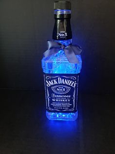 a bottle of jack daniels whiskey is lit up with blue lights and a bow on the top