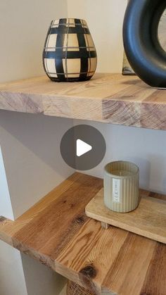 a wooden shelf with two vases on top of it and a candle in the middle