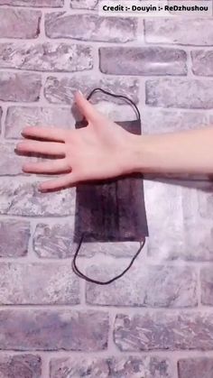 a person's arm and hand on a brick wall with an electric charger attached to it