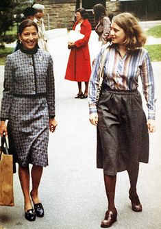 two women are walking down the street with shopping bags in their hands and one is wearing a dress