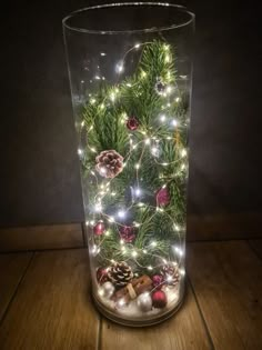 a glass vase filled with christmas decorations and lights