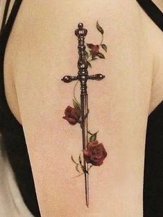 a cross tattoo with roses on the back of its neck, and an arrow in the middle