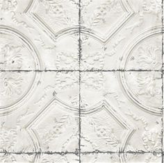 a white tile wall with an intricate design on it