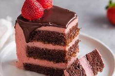 a piece of cake with chocolate frosting and two strawberries on the top slice