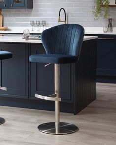 two blue bar stools sitting in front of a kitchen counter