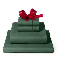 green sheets with red ribbon on top and two matching pillow cases in the same color