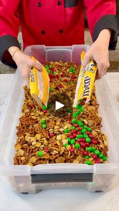 a woman in red jacket pouring cereal into bins with green and red candies