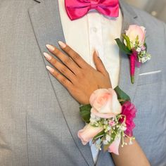 a close up of a person wearing a suit and tie with flowers on his lapel