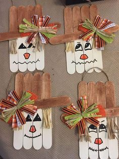 four popsicle scarecrows made out of wood sticks with ribbons and bows on them