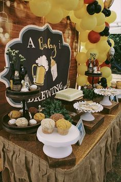 a table with cupcakes, muffins and balloons in the shape of a baby's 1st birthday sign