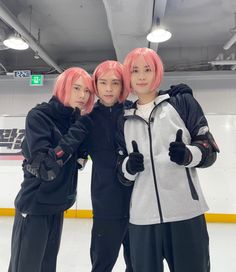 three young men standing next to each other in front of an ice rink with pink hair