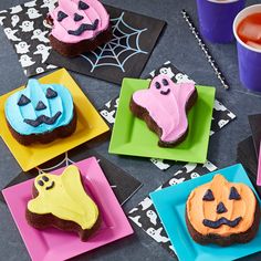 halloween ghost and pumpkin brownies on colorful plates with cupcakes in the background