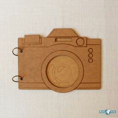 a wooden photo frame with a camera cut out on the front and bottom, attached to a wall